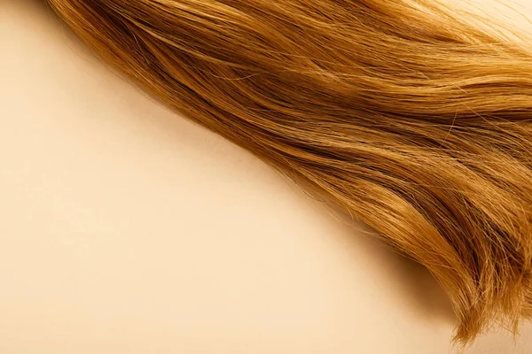 Vista dall'alto dei capelli castani su sfondo beige — Foto stock