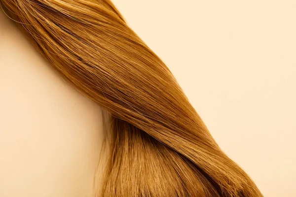 Top view of twisted brown hair on beige background — Stock Photo