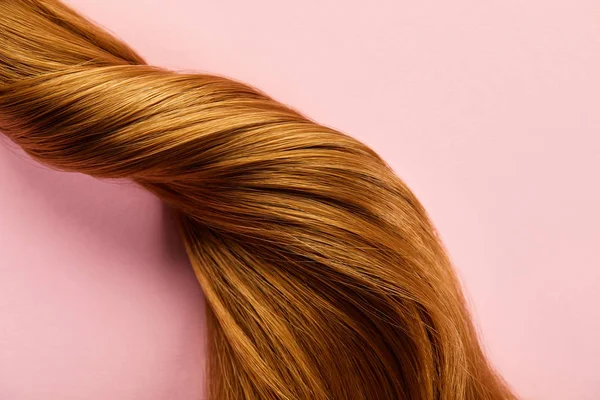 Vista dall'alto dei capelli castani intrecciati su sfondo rosa — Foto stock