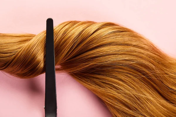 Top view of clip on twisted brown hair on pink background — Stock Photo