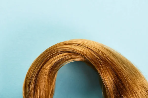 Top view of brown hair on blue background with copy space — Stock Photo