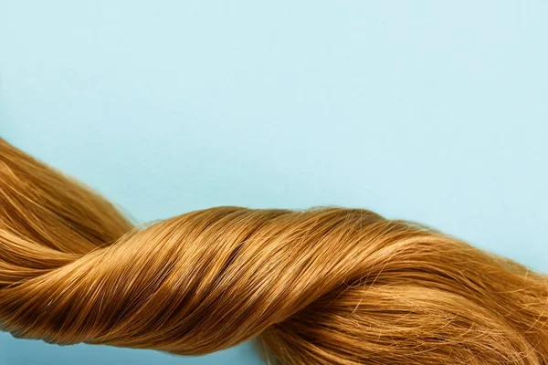 Vista dall'alto di capelli castani attorcigliati isolati su blu — Foto stock