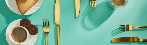 Top view of delicious cookies with coffee and cutlery on turquoise surface, panoramic shot — Stock Photo