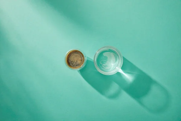 Vista superior de agua clara y café en vasos sobre fondo turquesa con espacio para copiar - foto de stock