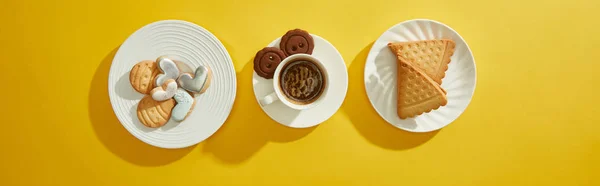 Top view of coffee cup and fresh cookies on yellow background, panoramic shot — Stock Photo
