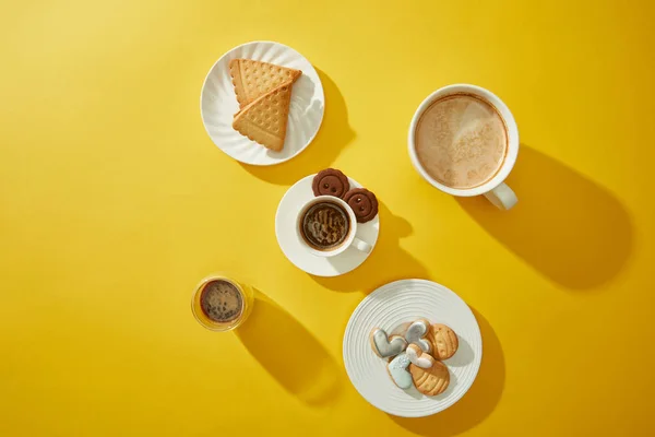 Vue du dessus du café avec de délicieux biscuits sur fond jaune — Photo de stock