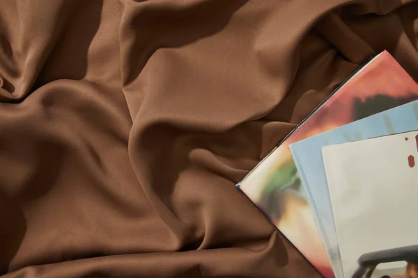 Top view of magazines on wavy brown tablecloth — Stock Photo