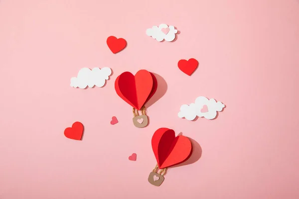 Top view of paper heart shaped air balloons in clouds on pink — Stock Photo