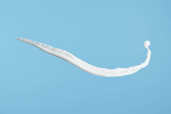 Spruzzi di latte fresco bianco isolato su blu — Foto stock