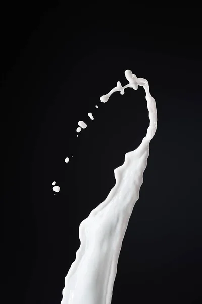 Éclaboussure de lait blanc frais avec des gouttes isolées sur noir — Photo de stock