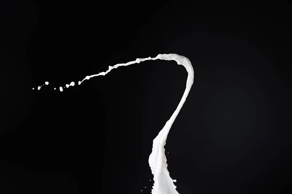 Frische weiße Milch spritzt mit Tropfen isoliert auf schwarz — Stockfoto