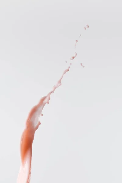 Salpicadura de leche rosa fresca con gotas aisladas en blanco - foto de stock