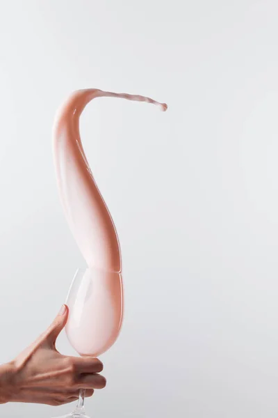 Vue recadrée de la femme tenant verre avec du lait rose frais éclaboussure lisse isolé sur blanc — Photo de stock