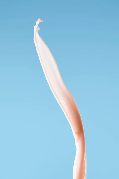 Glatte frische rosa Milchspritzer isoliert auf blau — Stockfoto