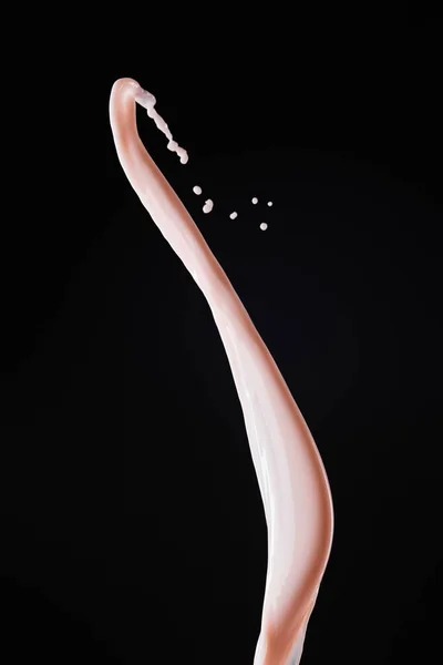 Smooth fresh pink milk splash with drops isolated on black — Stock Photo