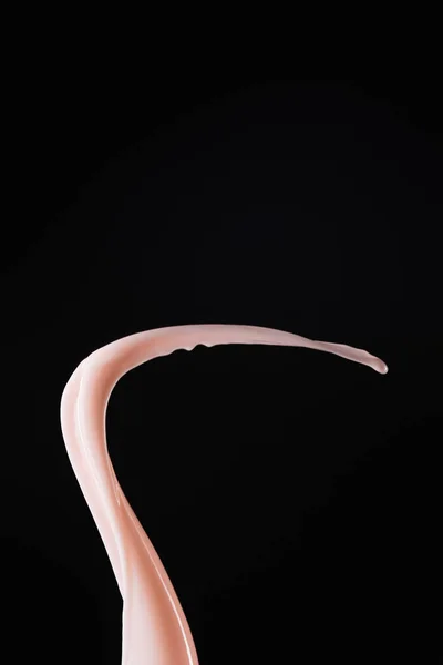 Glatte frische rosa Milchspritzer isoliert auf schwarz — Stockfoto