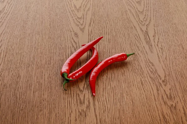 Pimientos picantes rojos sobre mesa marrón de madera - foto de stock