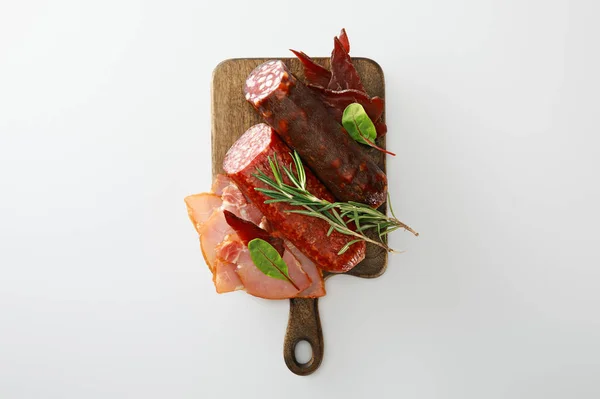 Vista superior de deliciosa bandeja de carne servida com alecrim em tábua de madeira isolada em branco — Fotografia de Stock