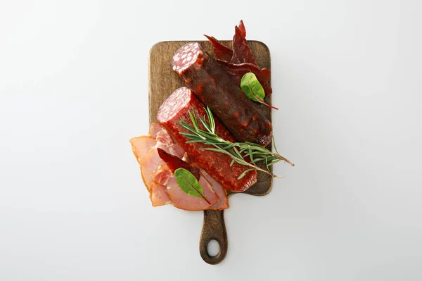 Top view of delicious meat platter served with rosemary on wooden board isolated on white — Stock Photo