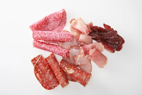 Вид сверху на свежее вкусное разнообразное нарезанное мясо, изолированное на белом — стоковое фото