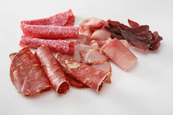 Fresca deliziosa carne affettata assortita isolata su bianco — Foto stock