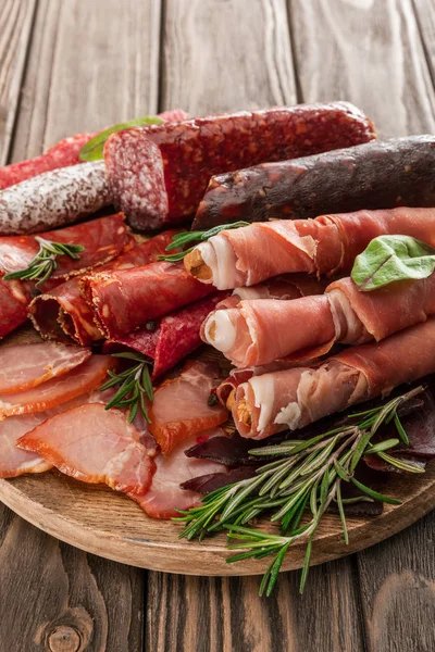Vista superior de prato de carne deliciosa servido com alecrim em tábua de madeira — Fotografia de Stock