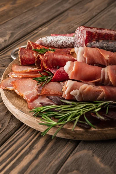 Delizioso piatto di carne servito con rosmarino su tavola di legno — Foto stock