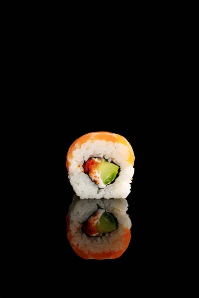Delicioso sushi Filadélfia com abacate, queijo cremoso, salmão e masago caviar isolado em preto com reflexão — Fotografia de Stock