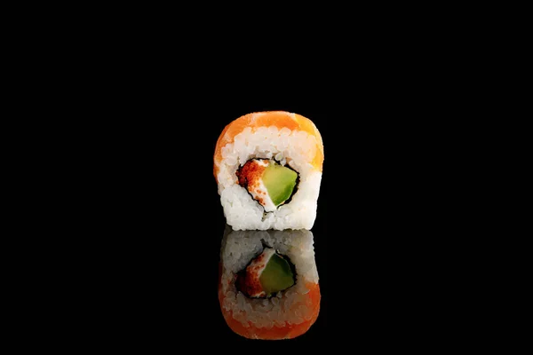 Fresh delicious Philadelphia sushi piece with avocado, creamy cheese, salmon and masago caviar isolated on black — Stock Photo