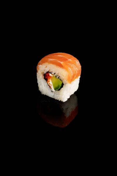 Fresco delizioso pezzo di sushi Philadelphia con avocado, formaggio cremoso, salmone e caviale masago isolato su nero — Foto stock