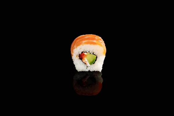 Fresh delicious Philadelphia sushi piece with avocado, creamy cheese, salmon and masago caviar isolated on black — Stock Photo