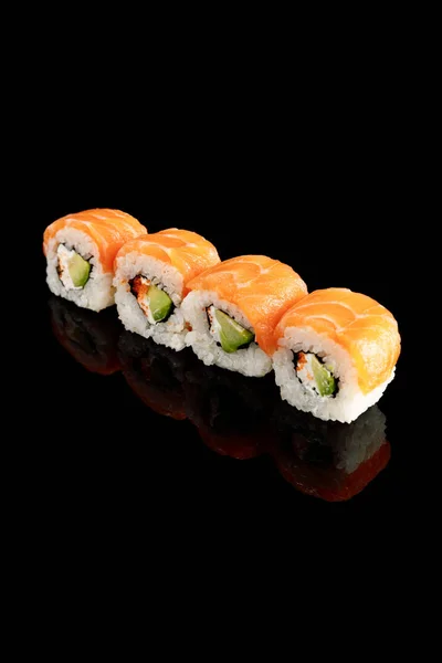 Fresh delicious Philadelphia sushi with avocado, creamy cheese, salmon and masago caviar isolated on black — Stock Photo