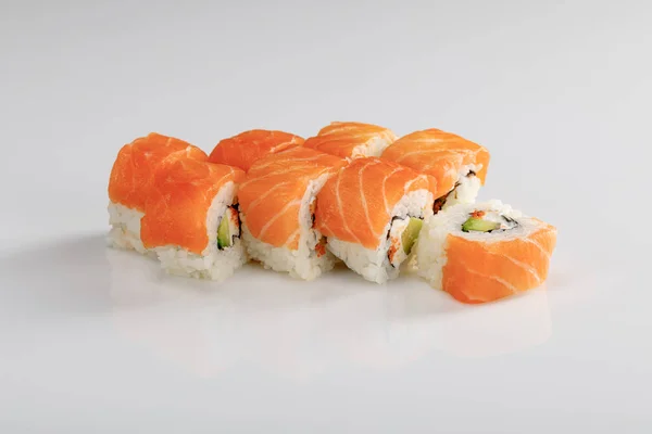 Delicious Philadelphia sushi with avocado, creamy cheese, salmon and masago caviar on white background — Stock Photo