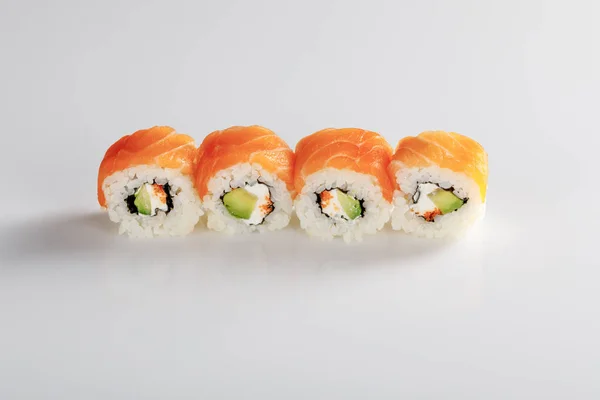 Delizioso sushi Philadelphia con avocado, formaggio cremoso, salmone e caviale masago su sfondo bianco — Foto stock