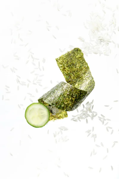 Top view of nori seaweed piece, cucumber slice and rice isolated on white — Stock Photo