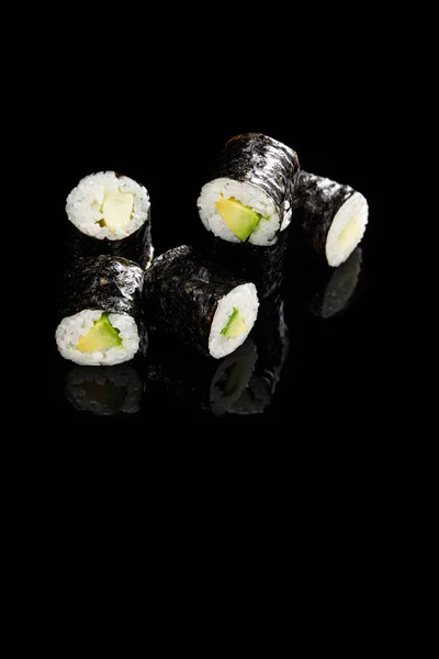 Köstliche Sushi Maki mit Avocado isoliert auf schwarz — Stockfoto