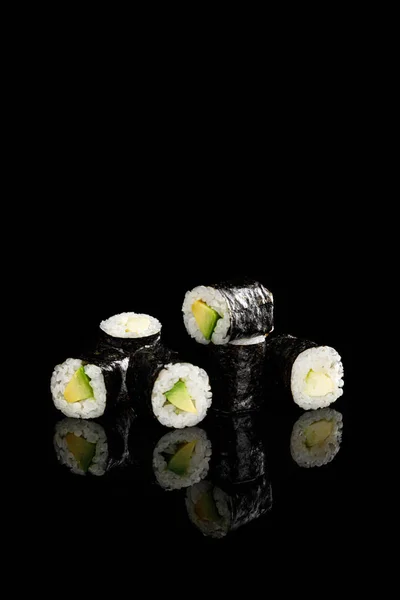 Delicioso sushi maki com abacate isolado em preto — Fotografia de Stock