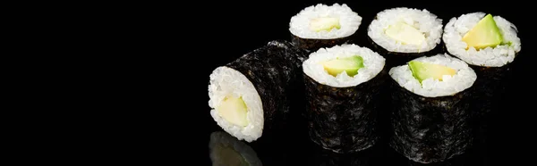 Delicious sushi maki with avocado isolated on black, panoramic shot — Stock Photo