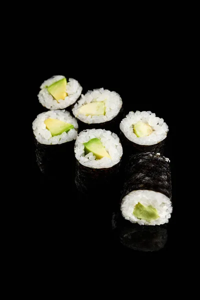 Köstliche Sushi Maki mit Avocado isoliert auf schwarz — Stockfoto