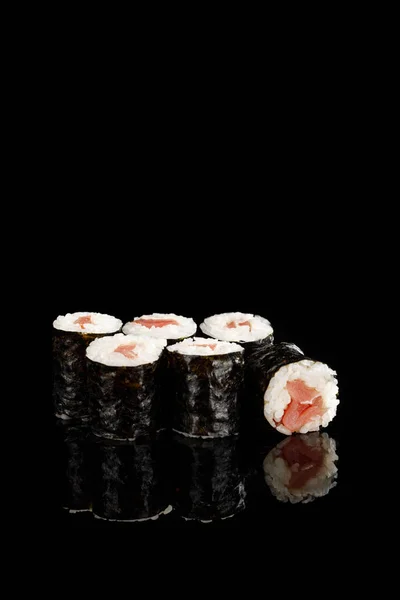 Delicioso sushi maki com atum isolado em preto — Fotografia de Stock