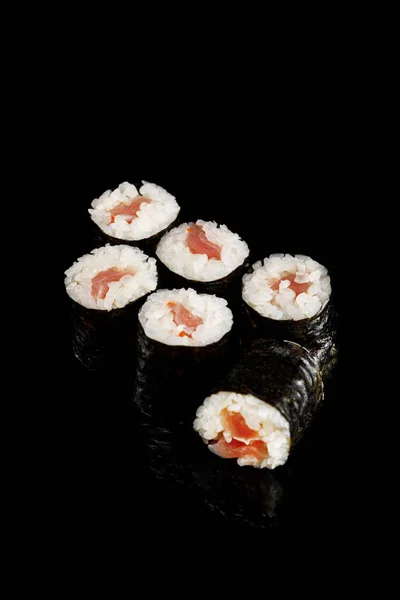 Delizioso sushi maki con tonno isolato su nero — Foto stock