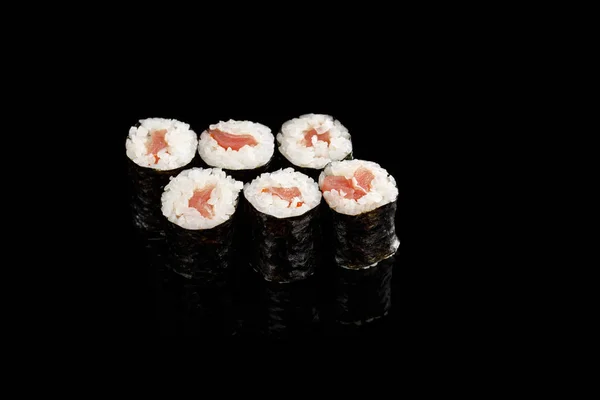 Delicioso sushi maki com atum isolado em preto — Fotografia de Stock