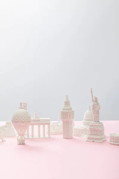 Kleine Souvenirs aus verschiedenen Ländern auf grau und rosa — Stockfoto