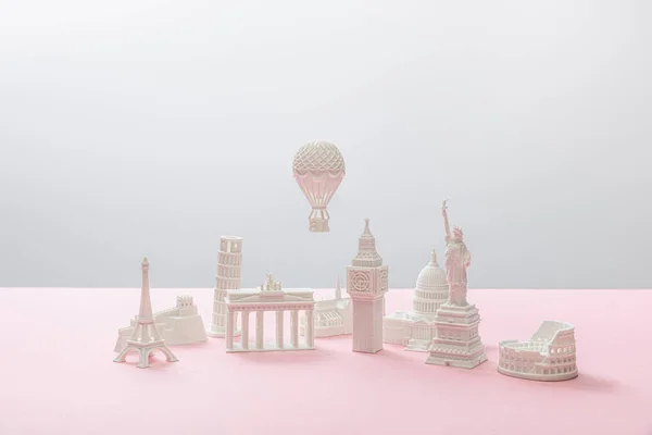 Kleine Figuren aus verschiedenen Ländern auf grau und rosa — Stockfoto
