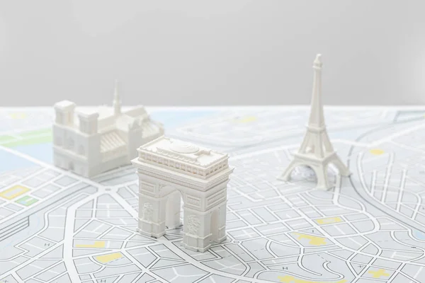 Selektiver Fokus der kleinen Figuren auf der Karte von Paris isoliert auf grau — Stockfoto
