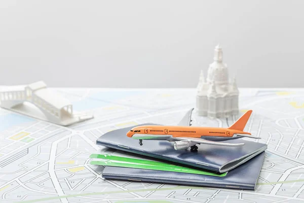 Enfoque selectivo de avión de juguete cerca de pasaportes y pequeñas figurillas en el mapa de italia aislado en gris - foto de stock