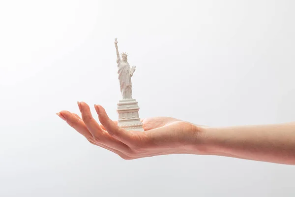 Vista cortada da mulher segurando pequena estátua de liberdade isolada no branco — Stock Photo