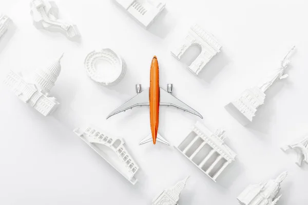 Vista superior del avión de juguete cerca de pequeñas estatuillas de diferentes países de Europa aisladas en blanco - foto de stock
