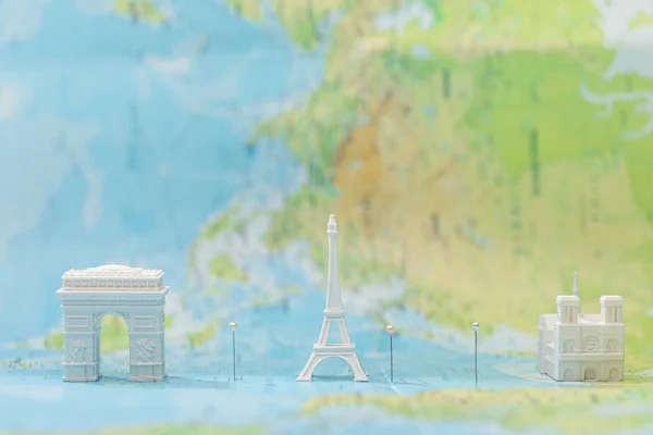 Pequenas estatuetas com atrações da cidade no mapa de paris com pinos — Fotografia de Stock