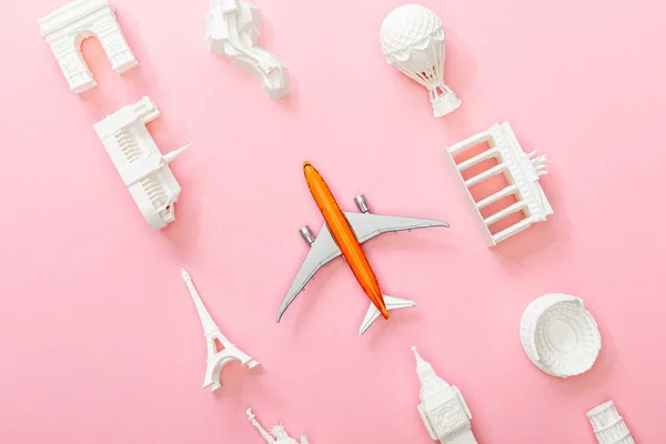 Vista superior de estatuetas de países perto de avião de brinquedo em rosa — Fotografia de Stock